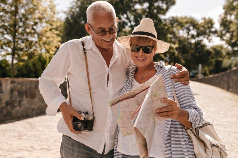 matrimonio de la tercera edad con una cámara y un mapa en la mano.